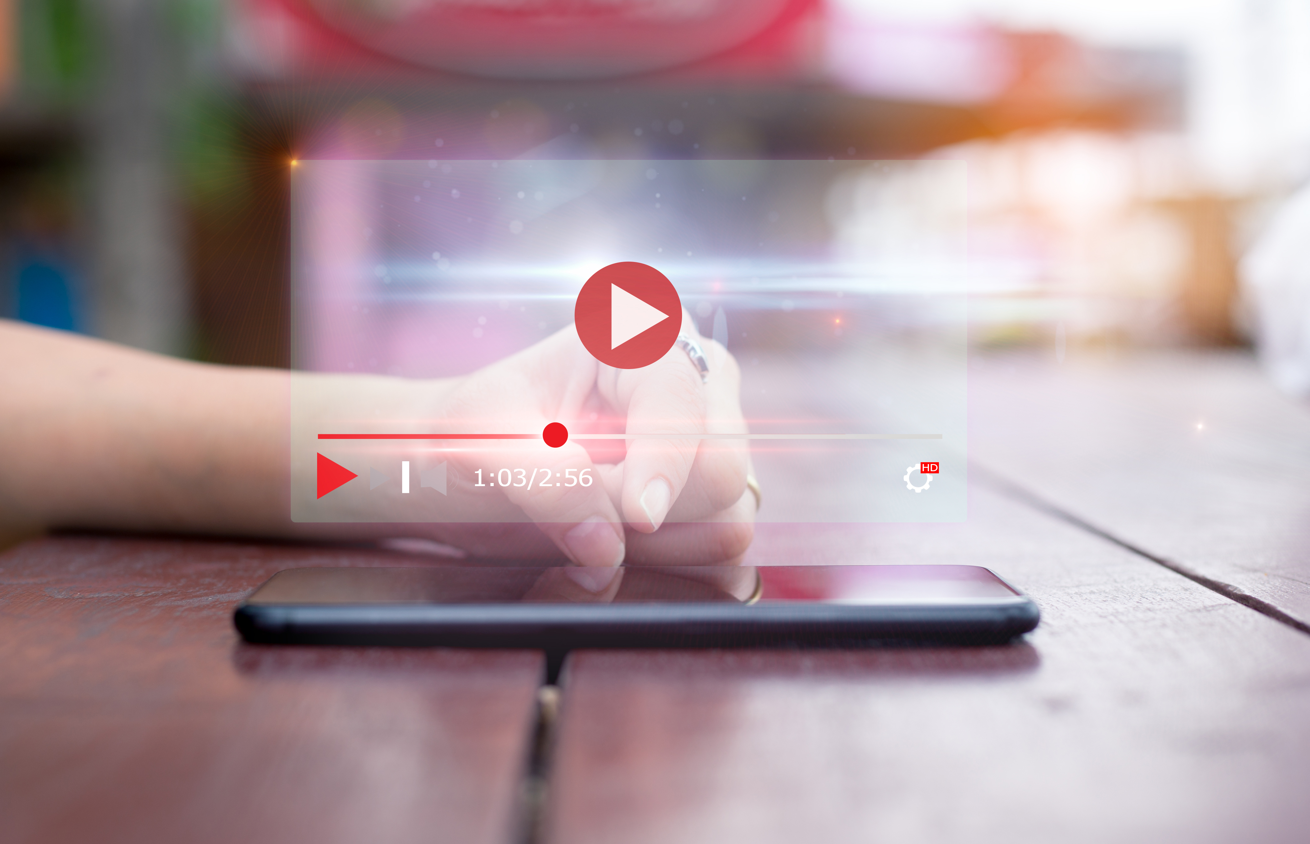 Hand using phone to view video marketing